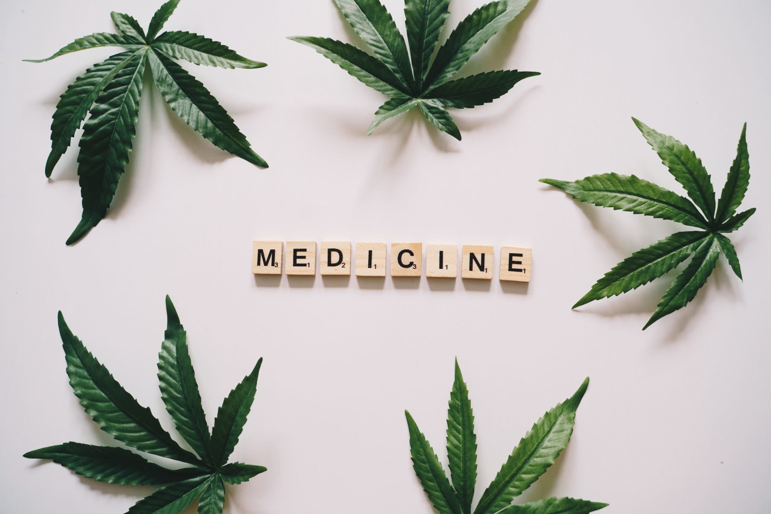 Marijuana leaves around the word, medicine spelt out with scrabble letters.